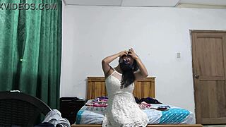 the busty executive slips into a white dress, moving sensually to show off her curves.