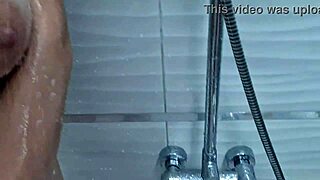 In the bathroom, this blonde milf showers her big tits while getting a massage.
