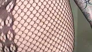 Paige wears fishnets while using a big black cock dildo.