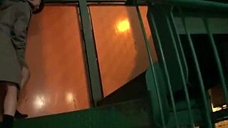 Asian girl walks night alley with remote vibrator attached.