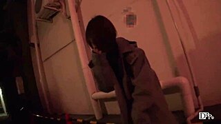 Asian girl walks night alley with remote vibrator attached.