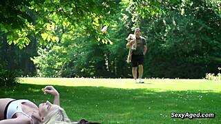 old man and sexy blonde in public park