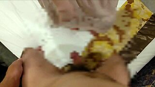 A guy gets his head crushed and balls slapped during a messy handjob, leading to a painful cum.