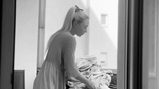 A chubby woman hangs out the laundry on the balcony for neighbors to watch