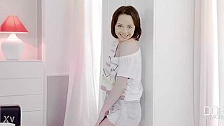 the young woman proudly shows off her smooth, hairless skin in the bedroom setting.