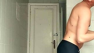 sexy guy casually shaving in black beach shorts