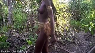 dark skinned african beauty dances seductively half naked in village forest showing perfect curves