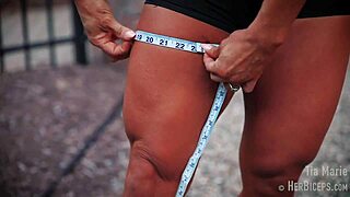 tia marie flexes her muscular biceps while showing off sexy redhead body in tape