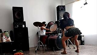 They drum while she dances, stripping her clothes and shaking that big curvy ass.