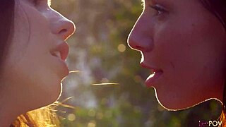 brunette and tattooed girl share intimate outdoor kisses and touches