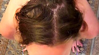 A nerdy wife with glasses kneels to service her partner closely, focusing on intimate connection.