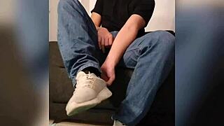 She strokes his cock perfectly between her socked feet