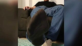 She strokes his cock perfectly between her socked feet