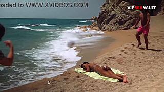 topless ebony babe oiled up on beach with hands under bikini