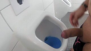 outdoor pool restroom pissing and jerking my thick shaved cock at urinal